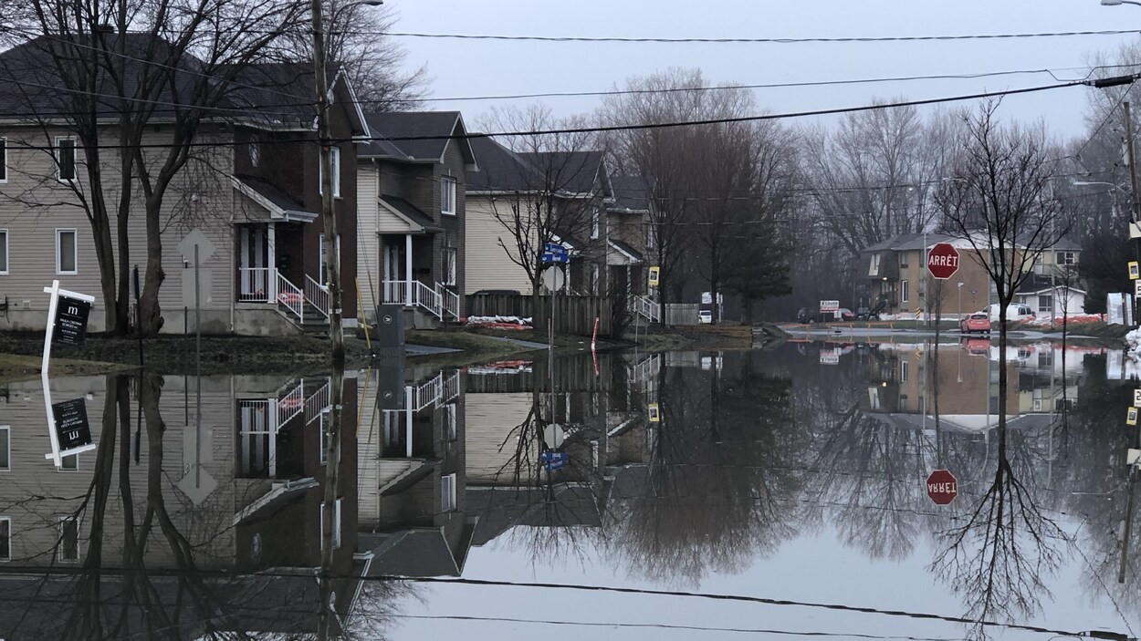 Des maisons dans une rue submergée par les eaux.