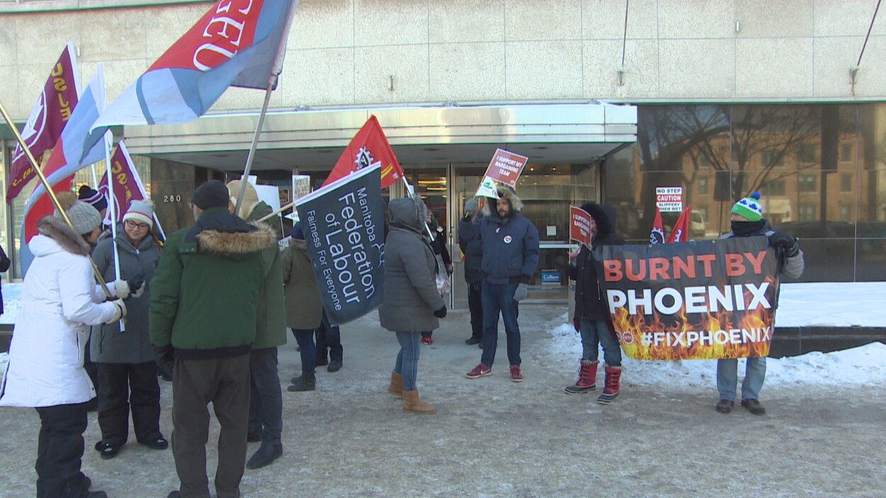 Des manifestants avec drapeaux, pancartes et banderole.