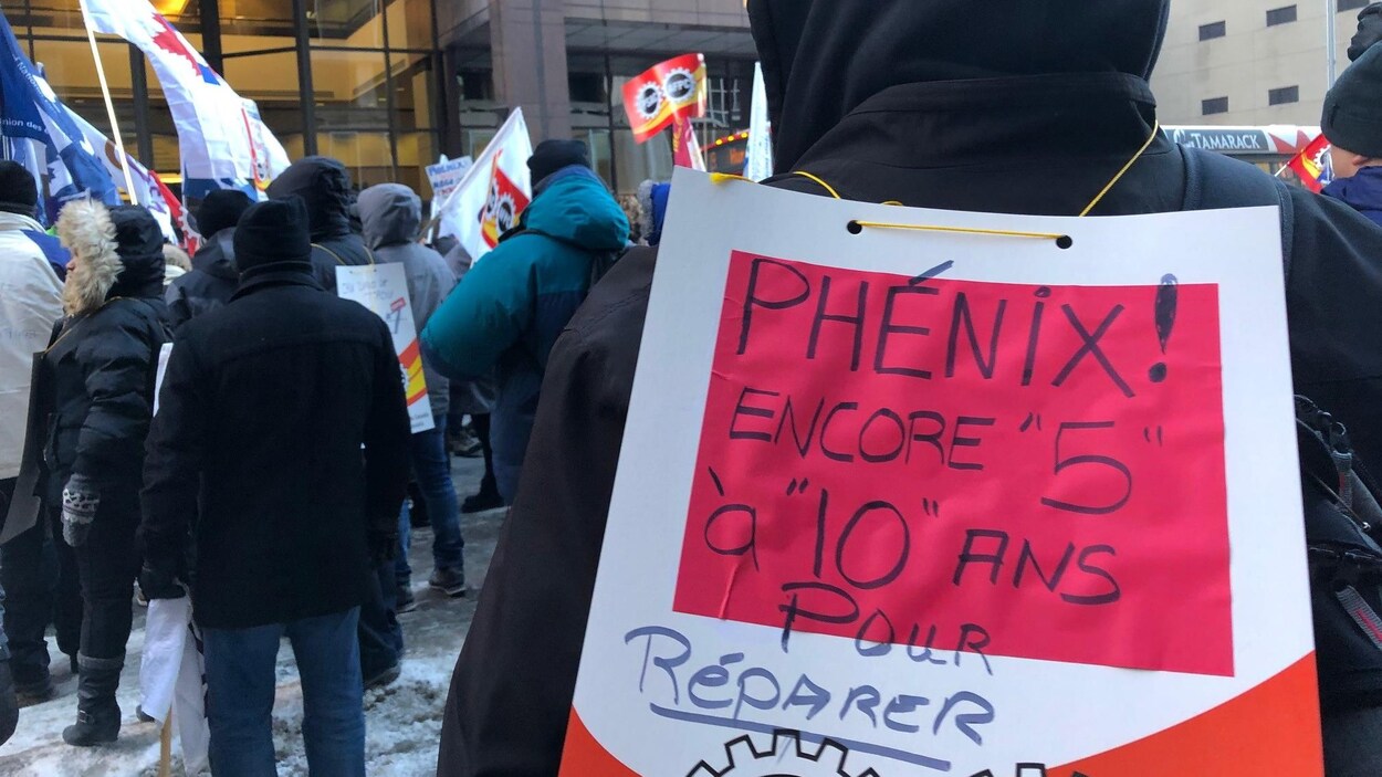 Un manifestant porte une affiche sur laquelle on peut lire : « Phénix encore 5 à 10 ans pour réparer ».