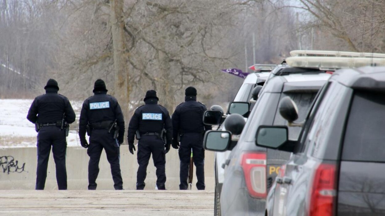 Des agents se tiennent debout en rangée.