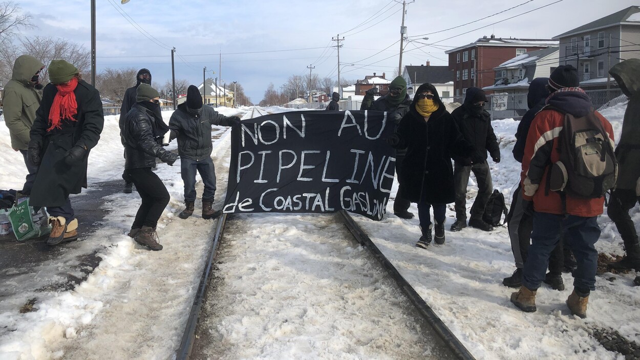 Manifestants masqués sur la voie ferrée près de la cantine de la Gare, à Rimouski.