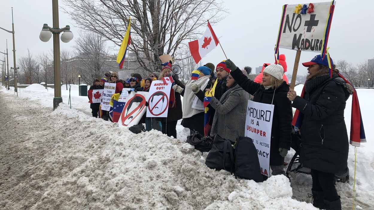 Des personnes tiennent des drapeaux et des pancartes.