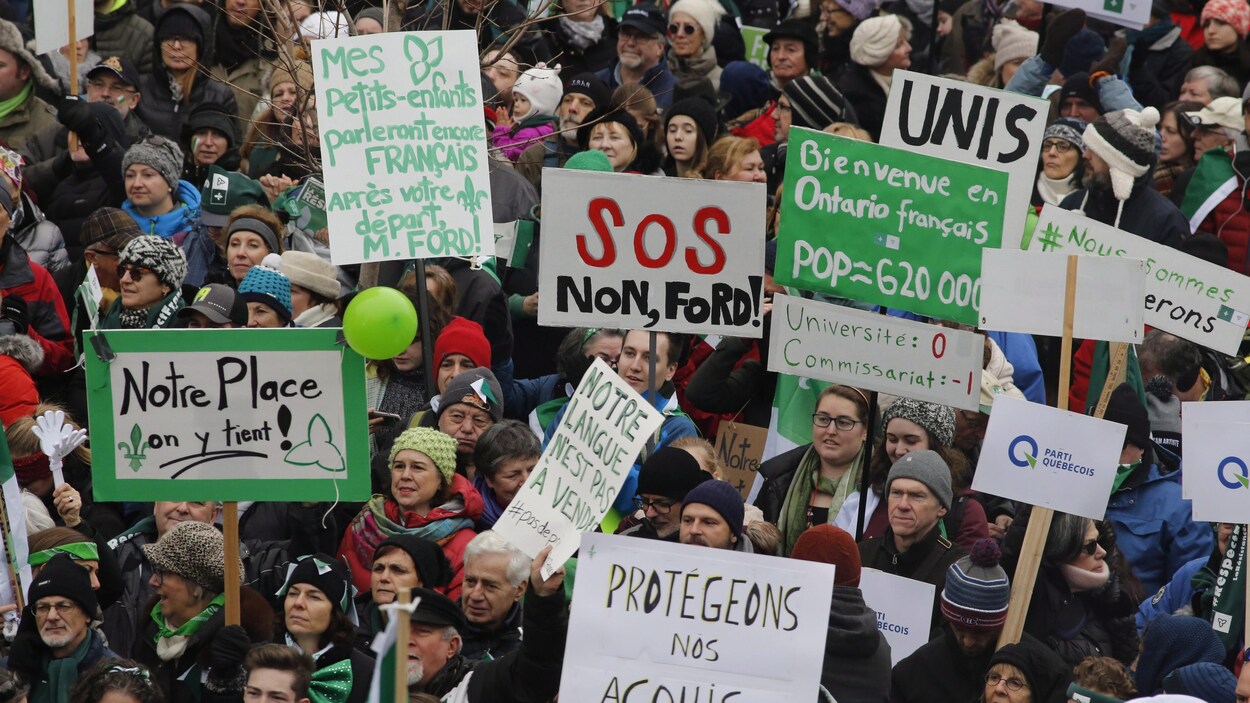 Une foule avec des pancartes.