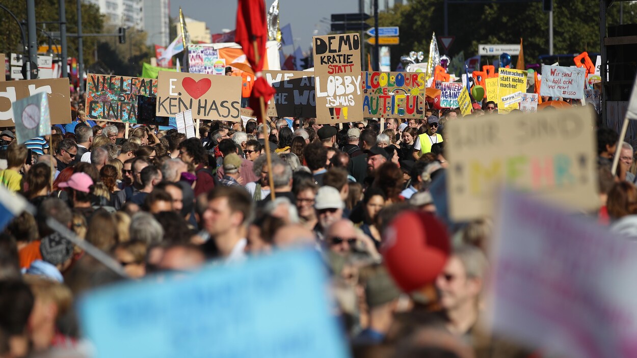 Une foule de gens marchent dans les rues de Berlin pendant une manifestation antiraciste. Une foule de gens marchent dans les rues de Berlin pendant une manifestation antiraciste.
