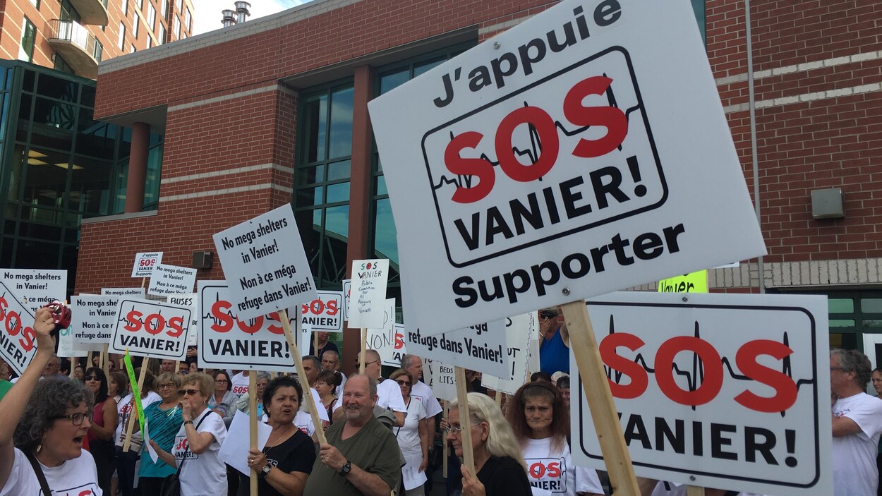 Des gens tiennent des pancartes affichant le message suivant : «J'appuie SOS Vanier supporter». Des gens tiennent des pancartes affichant le message suivant : «J'appuie SOS Vanier supporter».