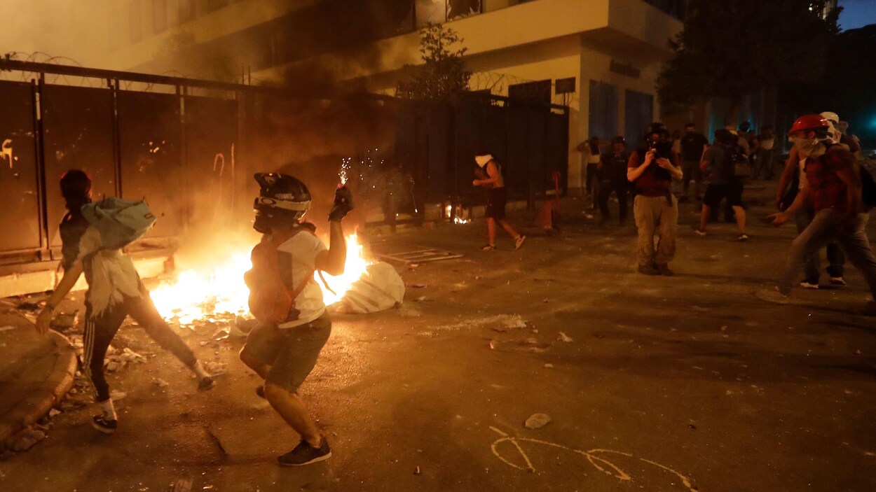 Les manifestants sont devant un petit incendie dans la rue.