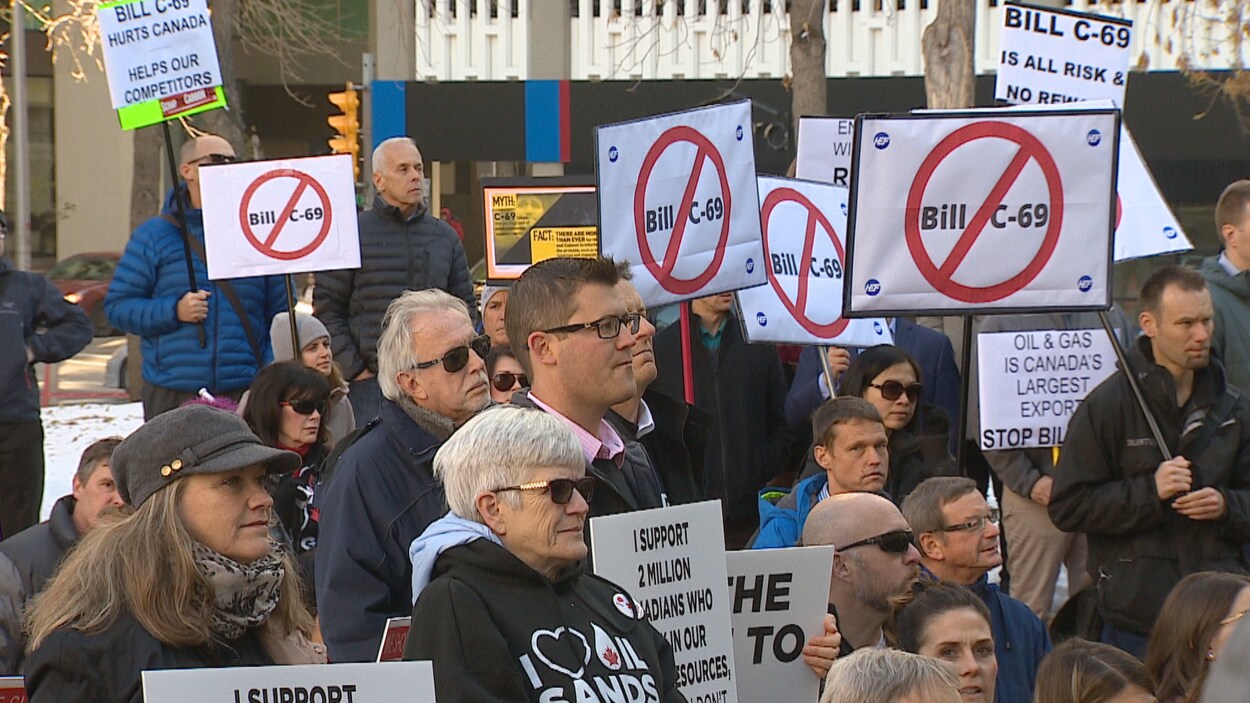 Des manifestants avec des pancartes contestataires.