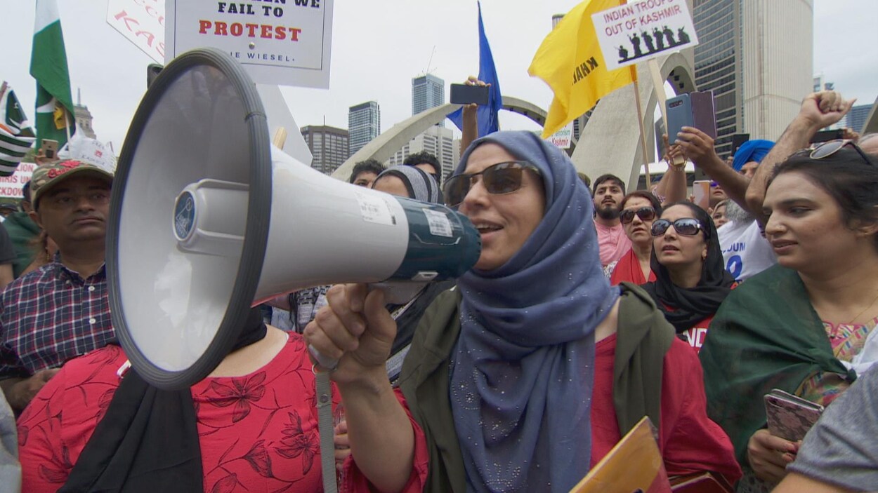 Un femme tient un mégaphone dans une manifestation