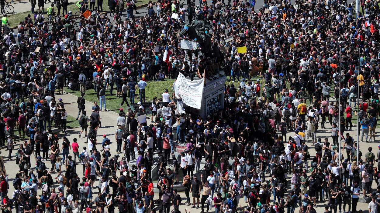Des personnes réunies lors d'une manifestation dans un parc.