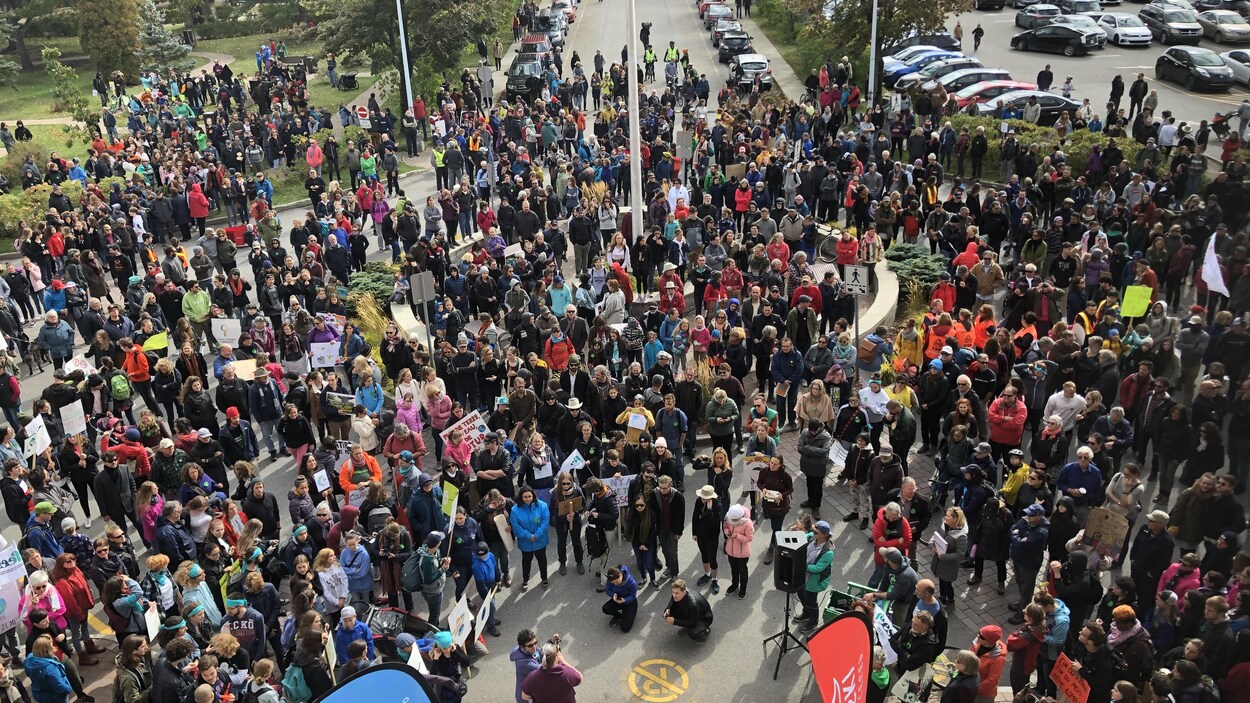Une vaste foule rassemblée dans la cour arrière du Cégep de Rimouski.