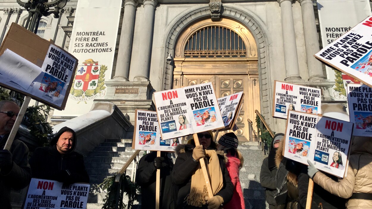 Les commerçants tiennent des pancartes sur lesquelles on peut lire : « Non à l'augmentation des taxes de la mairesse Plante » et « Mme Plante, vous n'avez pas de parole ».
