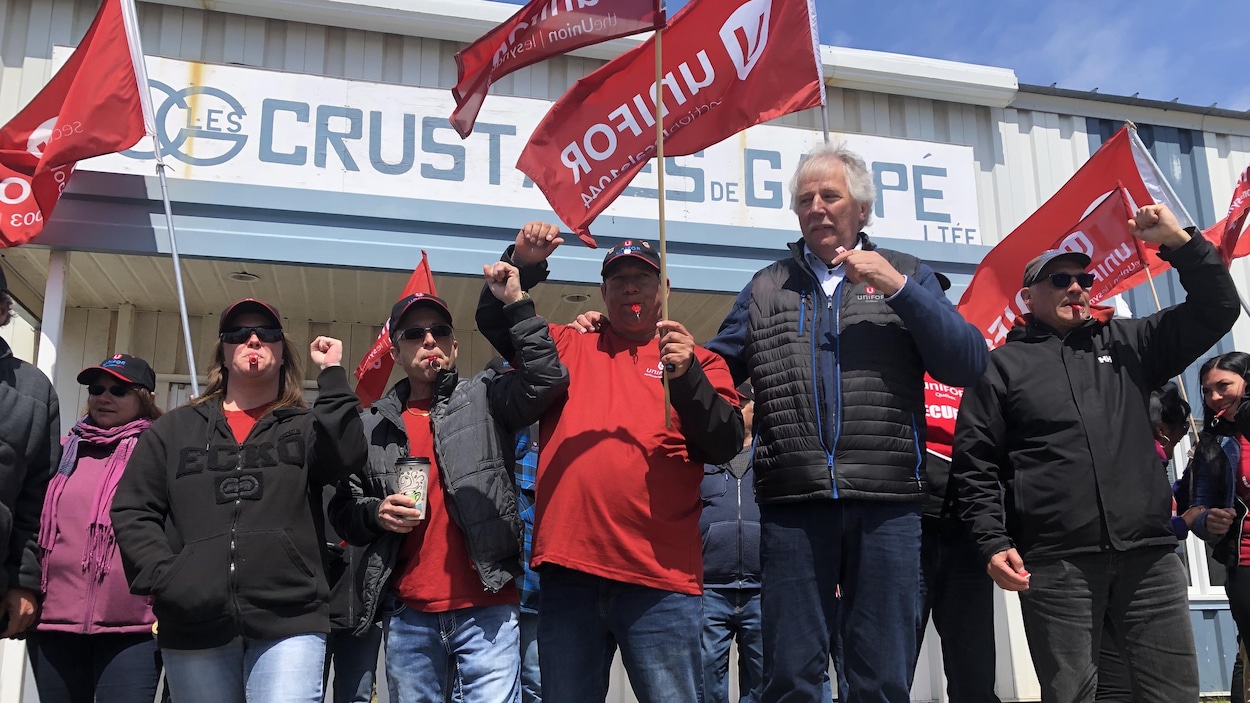 Manifestants devant une usine.