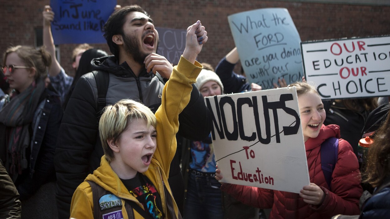 Photo d'élèves qui tiennent des pancartes sur lesquelles on peut lire « pas de coupes en éducation ».