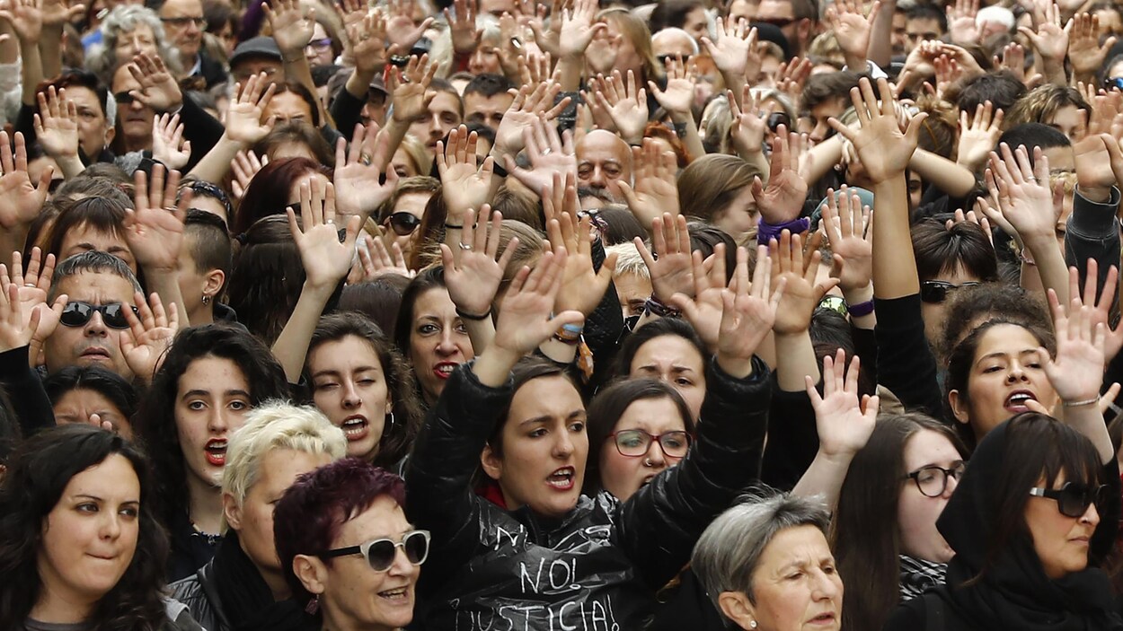 Plusieurs centaines de manifestants, les mains dans les airs, crient des slogans lors d'une marche dans les rues de Pampelune.
