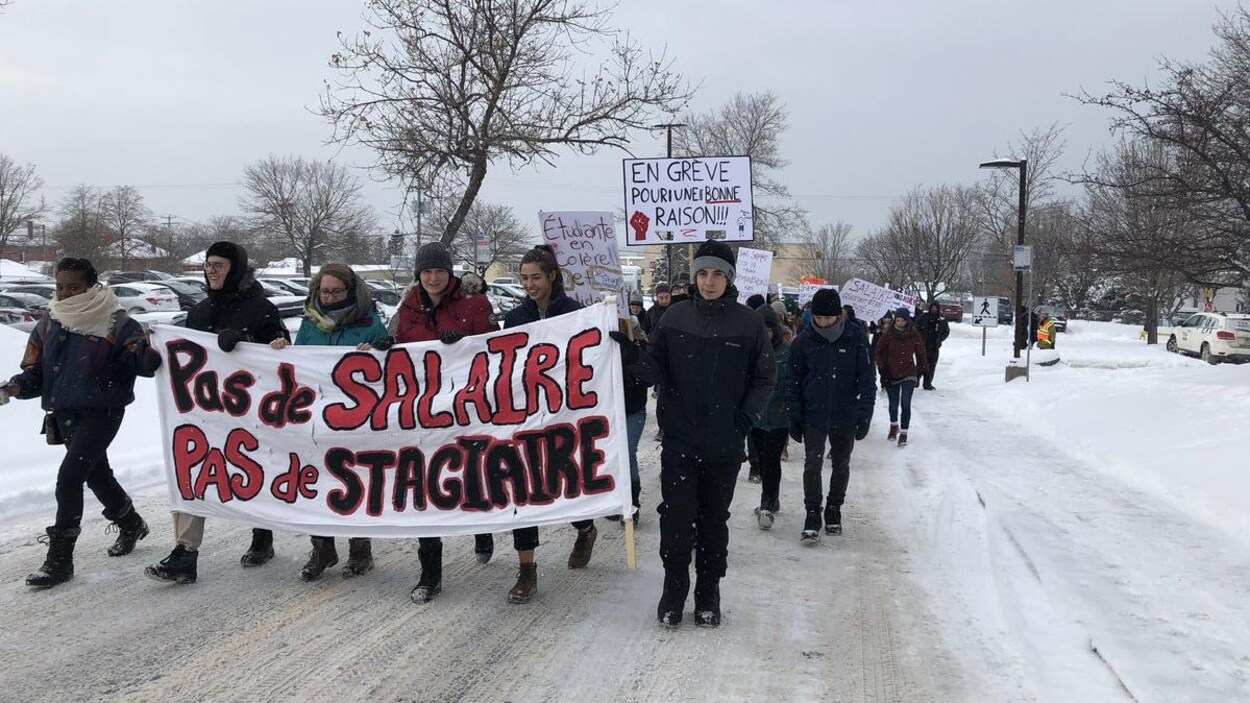 Des étudiants tiennent une banderole sur laquelle il est inscrit « Pas de salaire, pas de stagiaire »