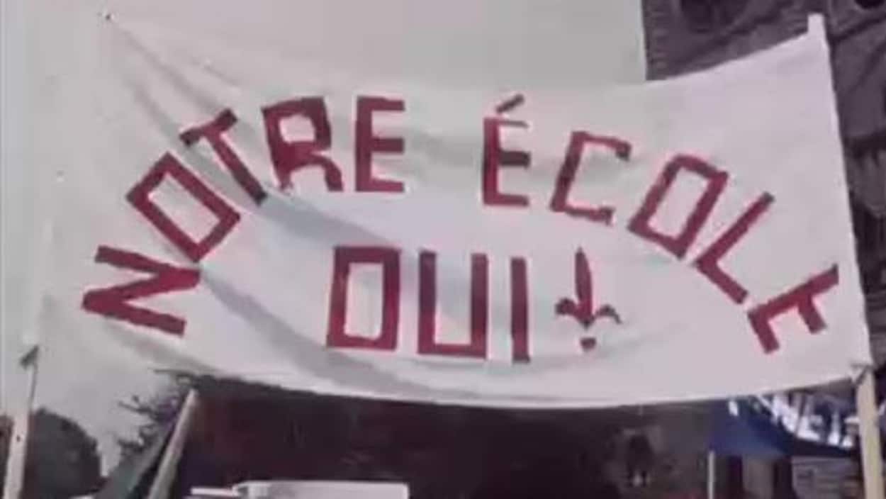 Grande bannière avec l'inscription «Notre école OUI» dans une manifestation Grande bannière avec l'inscription «Notre école OUI» dans une manifestation