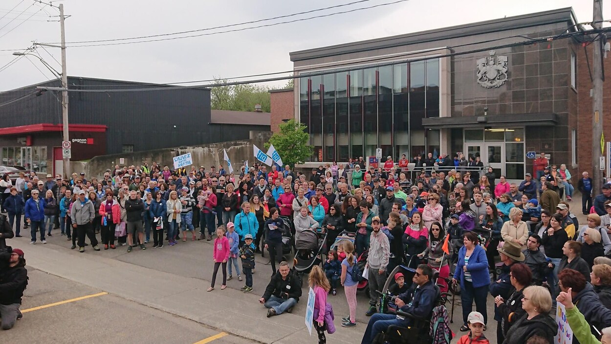 Une foule composée de personnes de tous les âges manifeste dans les rues de La Malbaie.
