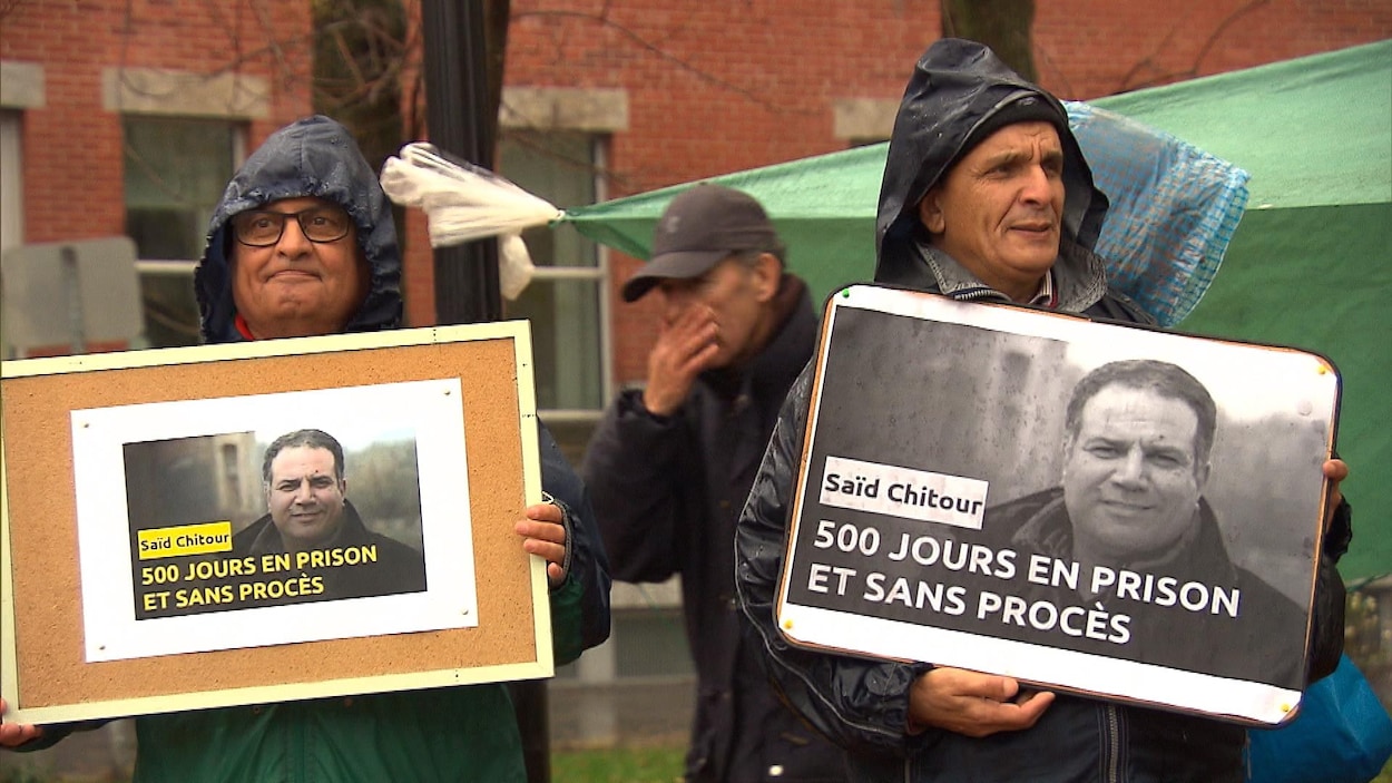 Deux personnes tenant des affichettes appelant à la libération d'un journaliste emprisonné