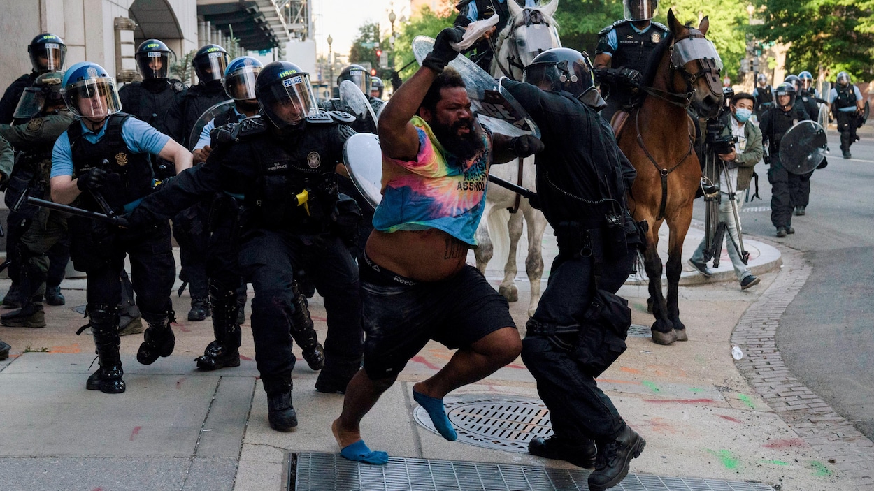 Un manifestant pourchassé par plusieurs policiers.
