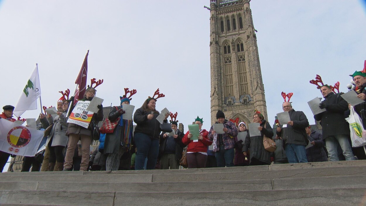 Des personnes devant la tour de la paix, l'édifice du centre de la colline du Parlement à Ottawa. Des personnes devant la tour de la paix, l'édifice du centre de la colline du Parlement à Ottawa.