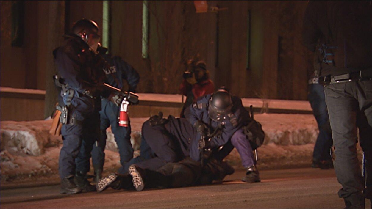 Des policiers arrêtent un manifestant. Des policiers arrêtent un manifestant.