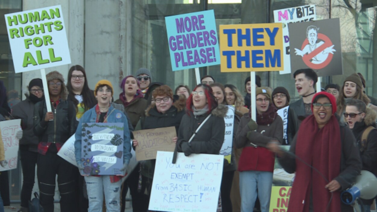 Des manifestants portant des pancartes sont rassemblés devant le Musée des beaux-arts d'Ottawa.