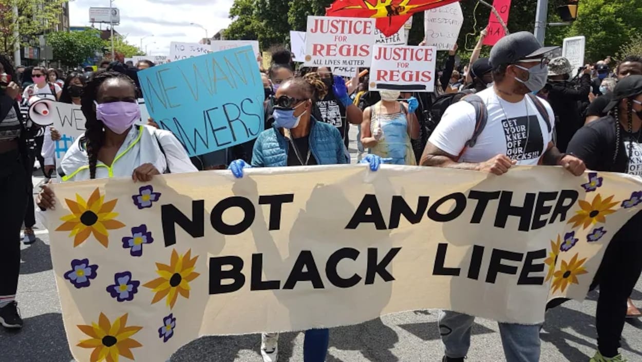 Les manifestants tiennent une banderole portant le message « pas une autre vie d'un Noir perdue ».