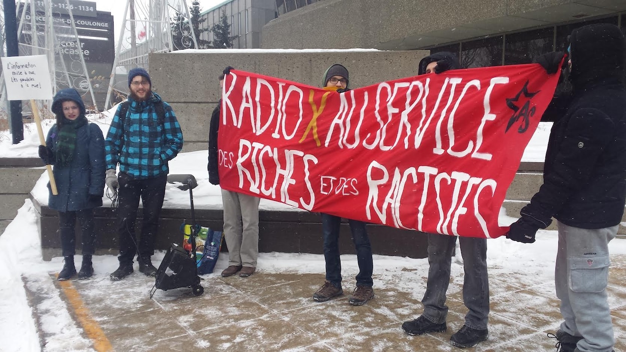 Quelques personnes se sont réunies devant les bureaux de CHOI Radio X pour manifester contre les radios parlées