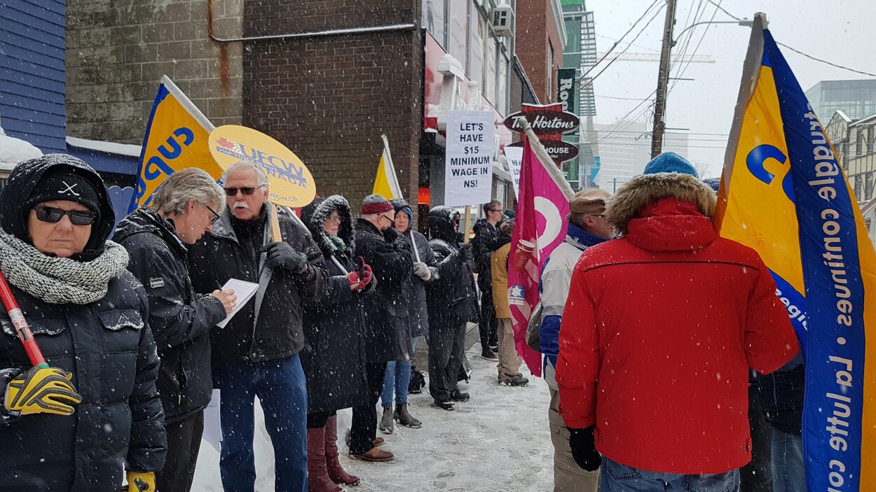 Groupe de manifestants sur le trottoir devant un Tim Hortons. Groupe de manifestants sur le trottoir devant un Tim Hortons.
