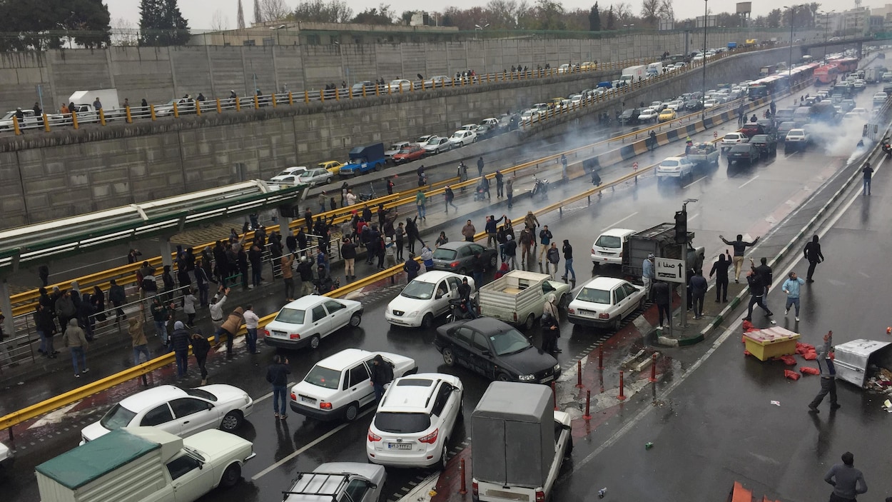 Des automobilistes arrêtent leur voiture sur une autoroute.
