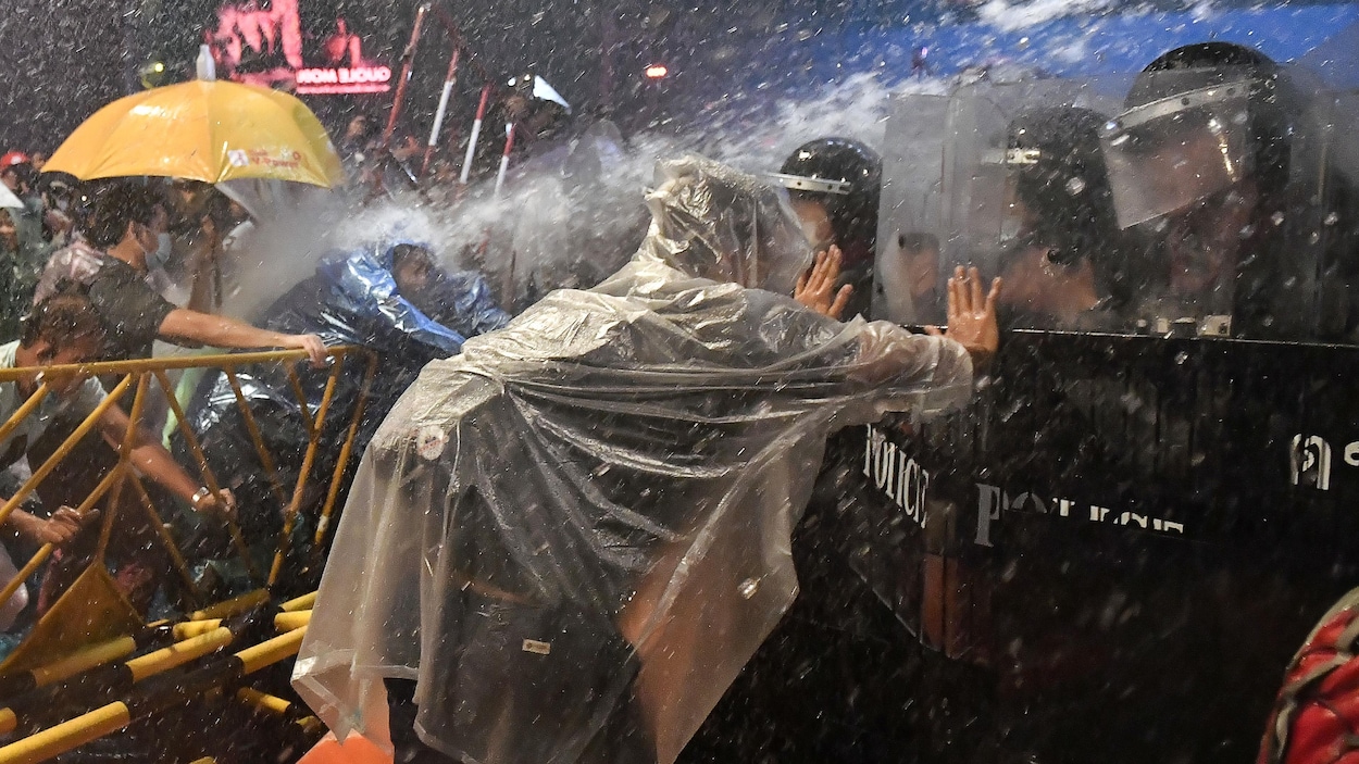 Des manifestants et policiers s'affrontent sous les jets d,eau.