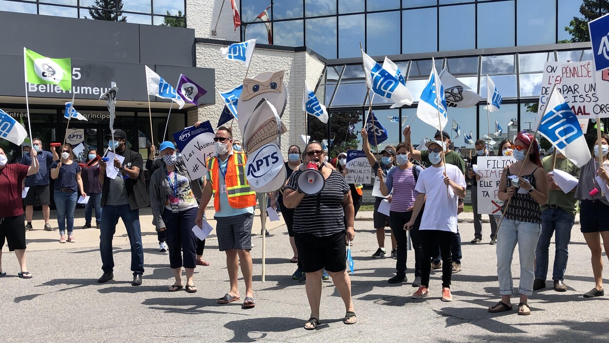 Des personnes manifestent en tenant des pancartes devant les bureaux du CISSSO.