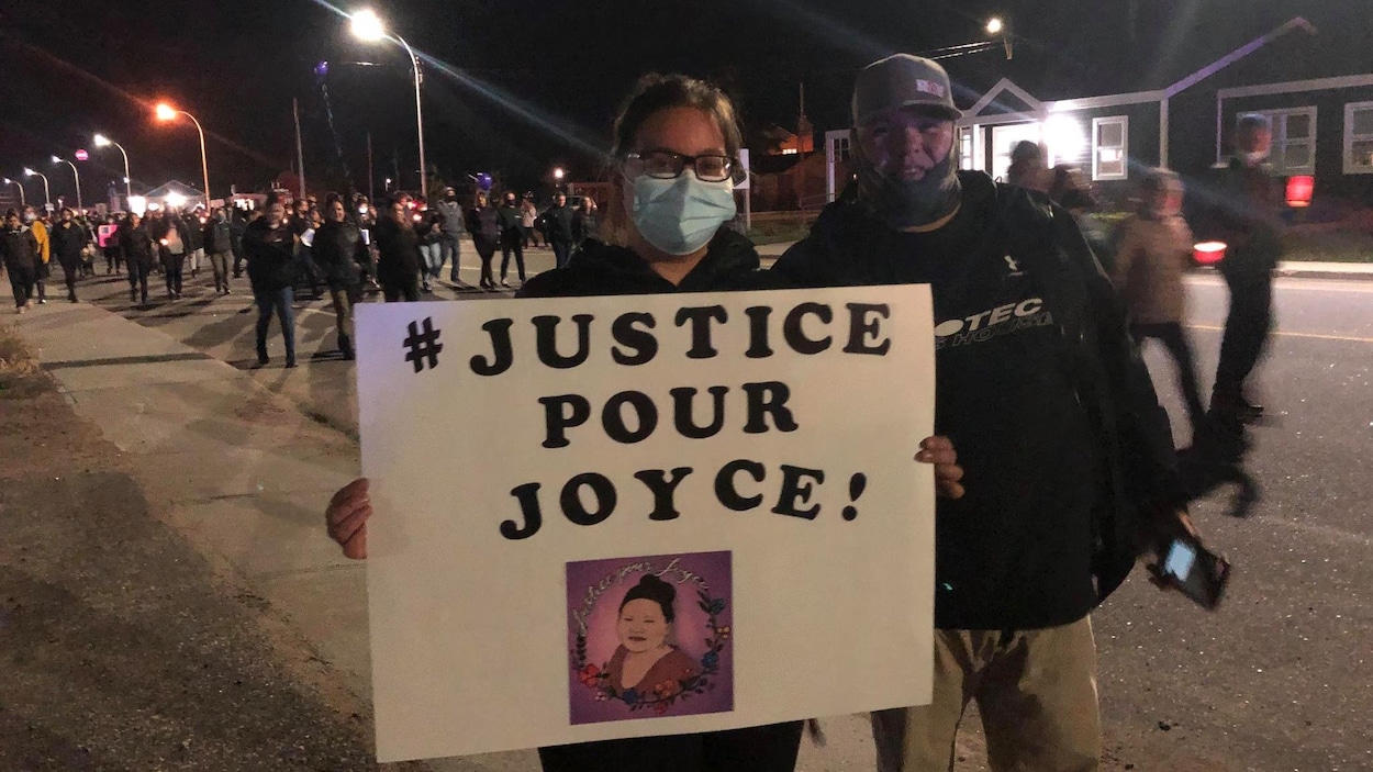 Un couple avec une affiche "Justice pour Joyce!"