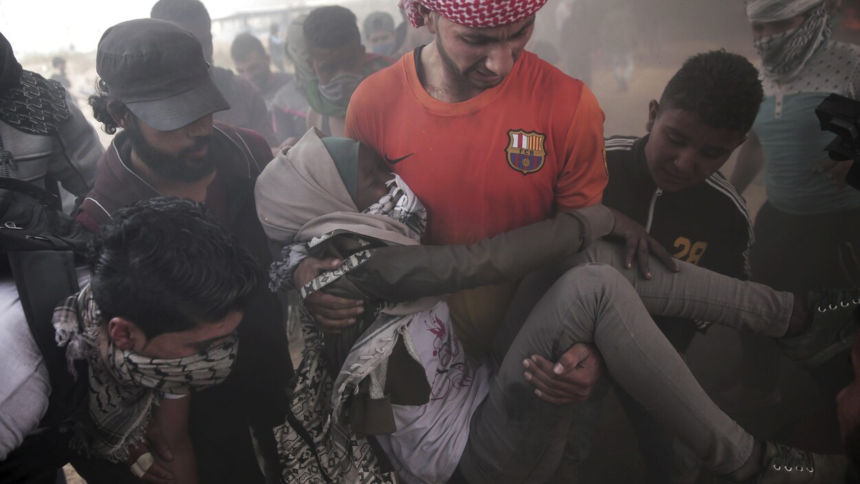 Les manifestants palestiniens évacuent une femme blessée lors des affrontements avec les soldats israéliens. Les manifestants palestiniens évacuent une femme blessée lors des affrontements avec les soldats israéliens.
