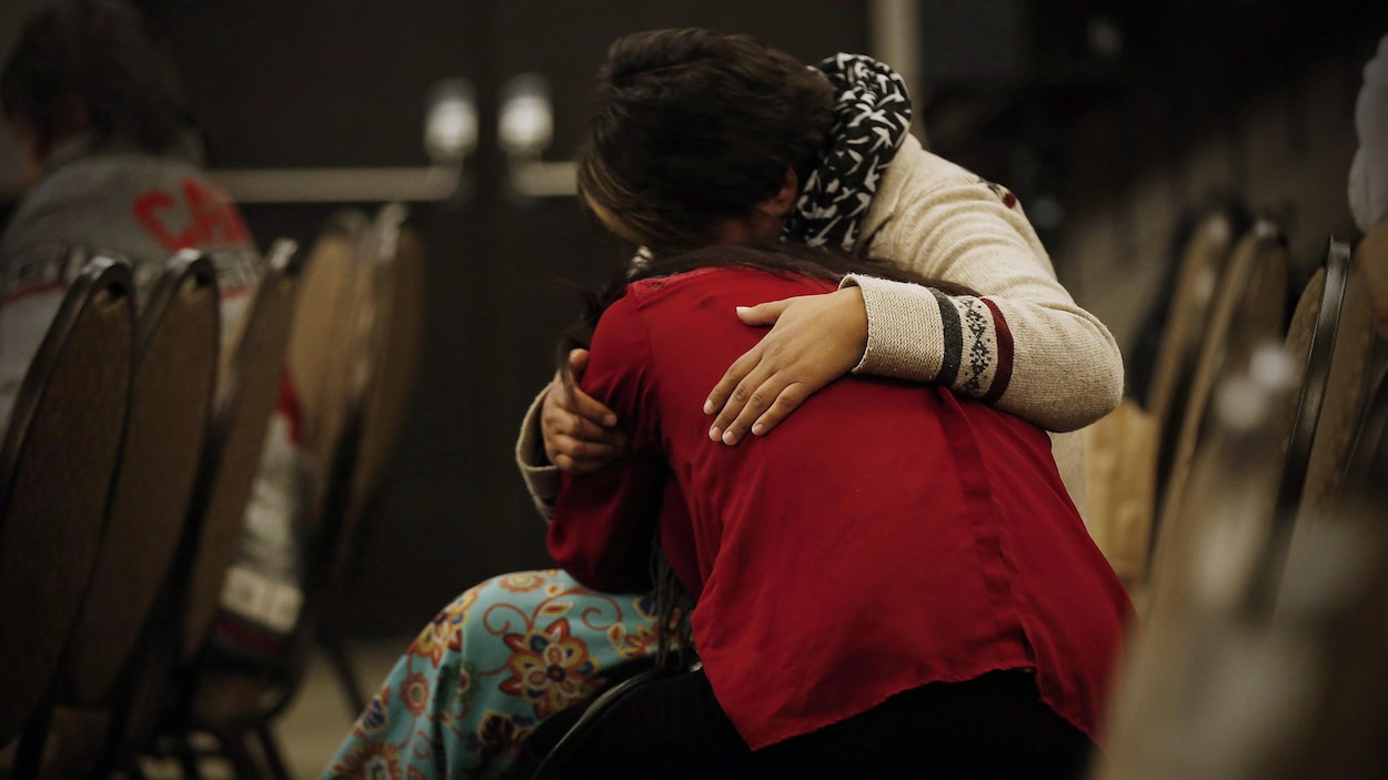 Deux femmes autochtones se réconfortent lors d'une séance de témoignages de l'Enquête nationale sur les femmes et les filles autochtones disparues et assassinées
