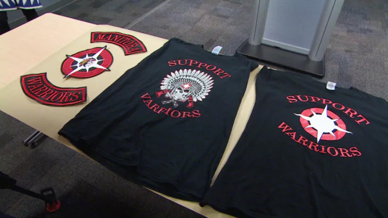 Des t-shirts de gangs de rue des Manitoba Warriors sont disposés sur une table.