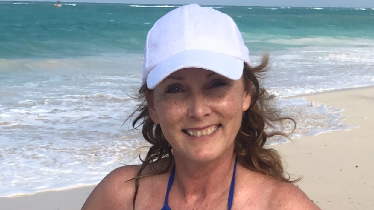 Une femme debout au bord de la mer.