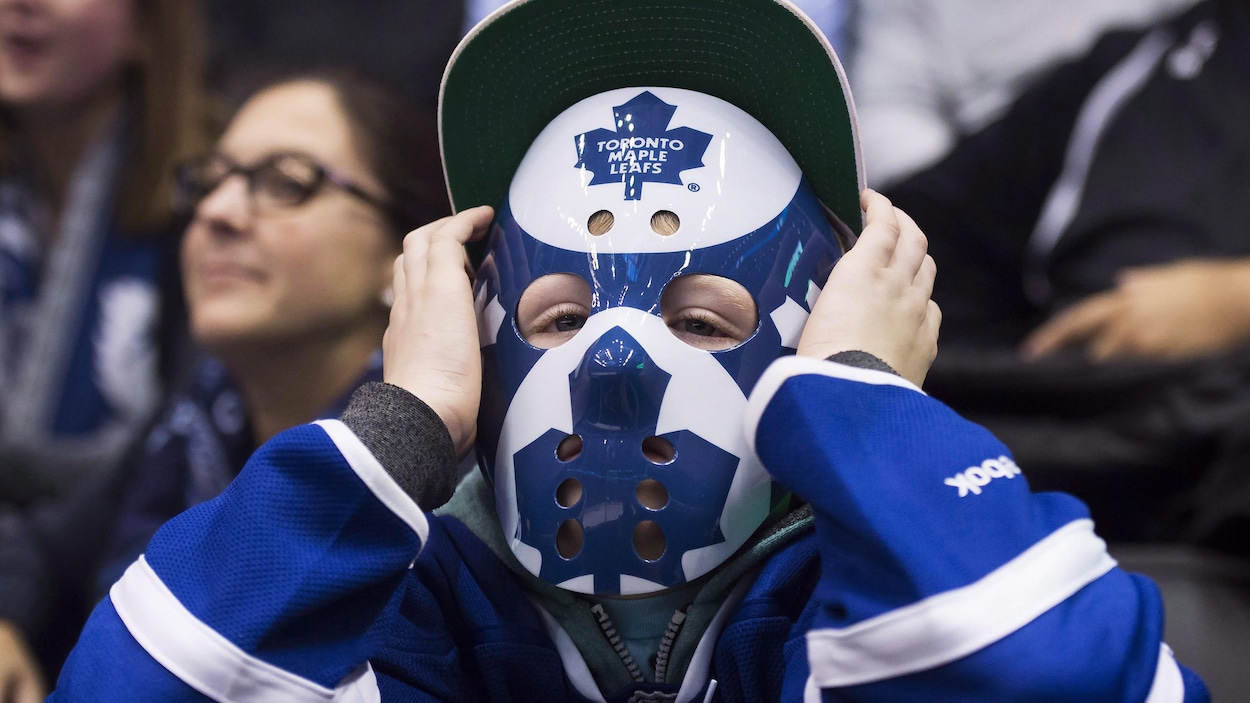 Un jeune partisan des Maple Leafs qui porte un masque aux couleurs de l'équipe. Un jeune partisan des Maple Leafs qui porte un masque aux couleurs de l'équipe.
