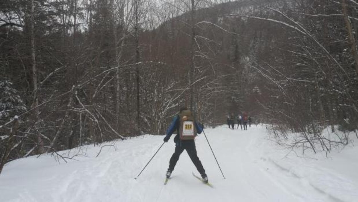 Un participant du Marathon canadien de ski dans la forêt.