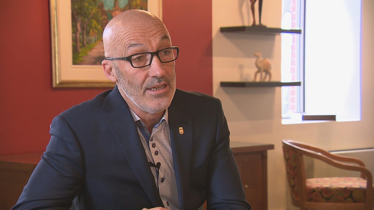 Le maire Marc Parent est assis à une table lors d'une entrevue.