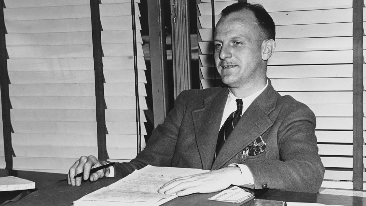Le directeur de la radio de la Société Radio-Canada, Marcel Ouimet, assis à son bureau, en 1947.