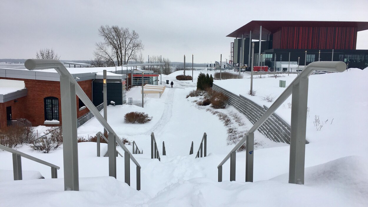 Neige sur des marches près de Boréalis, avec l'amphithéâtre Cogeco au loin.