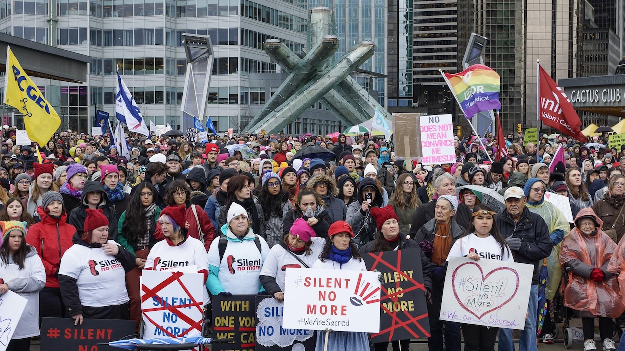 Des manifestantes à Vancouver avec des pancartes