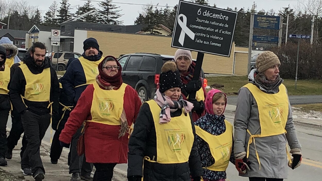 Des gens marchent avec des pancartes.