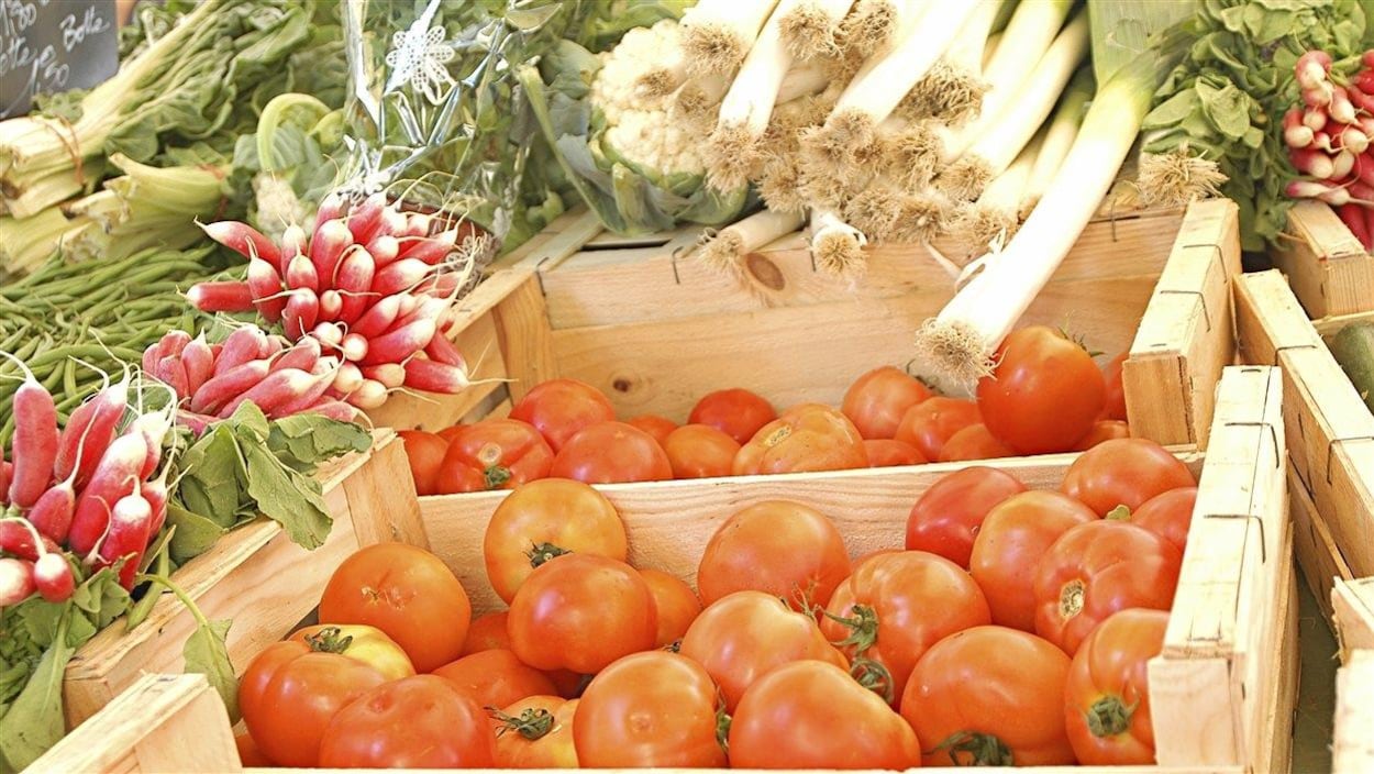 Des légumes en vente sur un marché public.