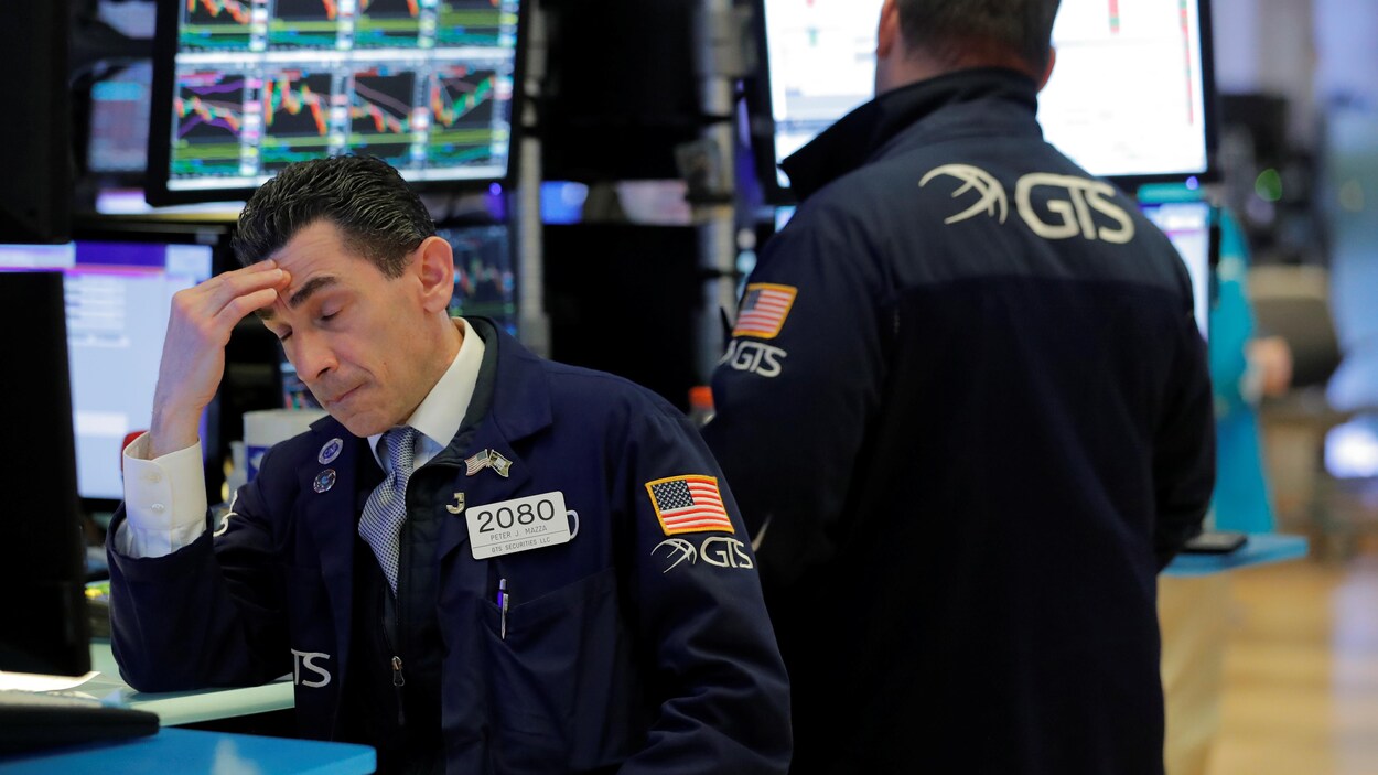 Un homme se masse le front sur le parquet du NYSE.
