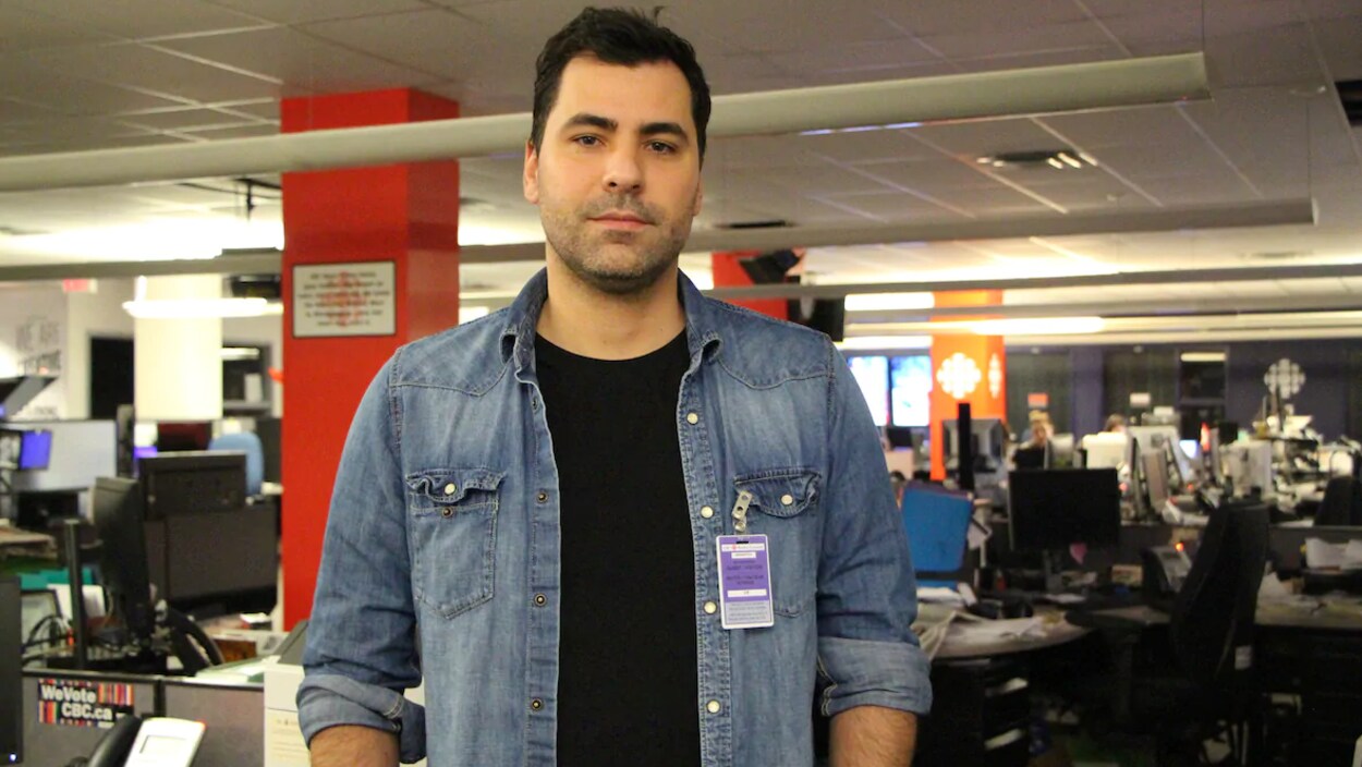 Marco Sousa pose pour la caméra dans la salle des nouvelles de Radio-Canada.