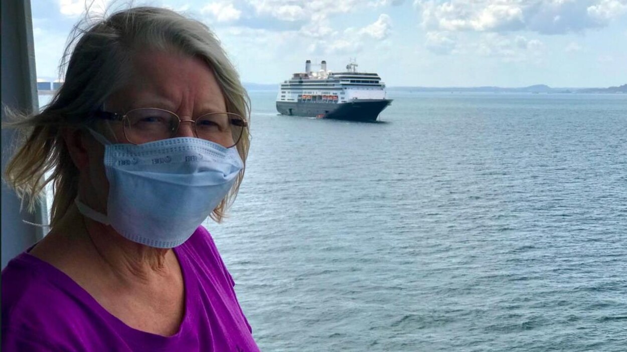 Margaret Tilley porte un masque sur le quai d'un bateau de croisière.