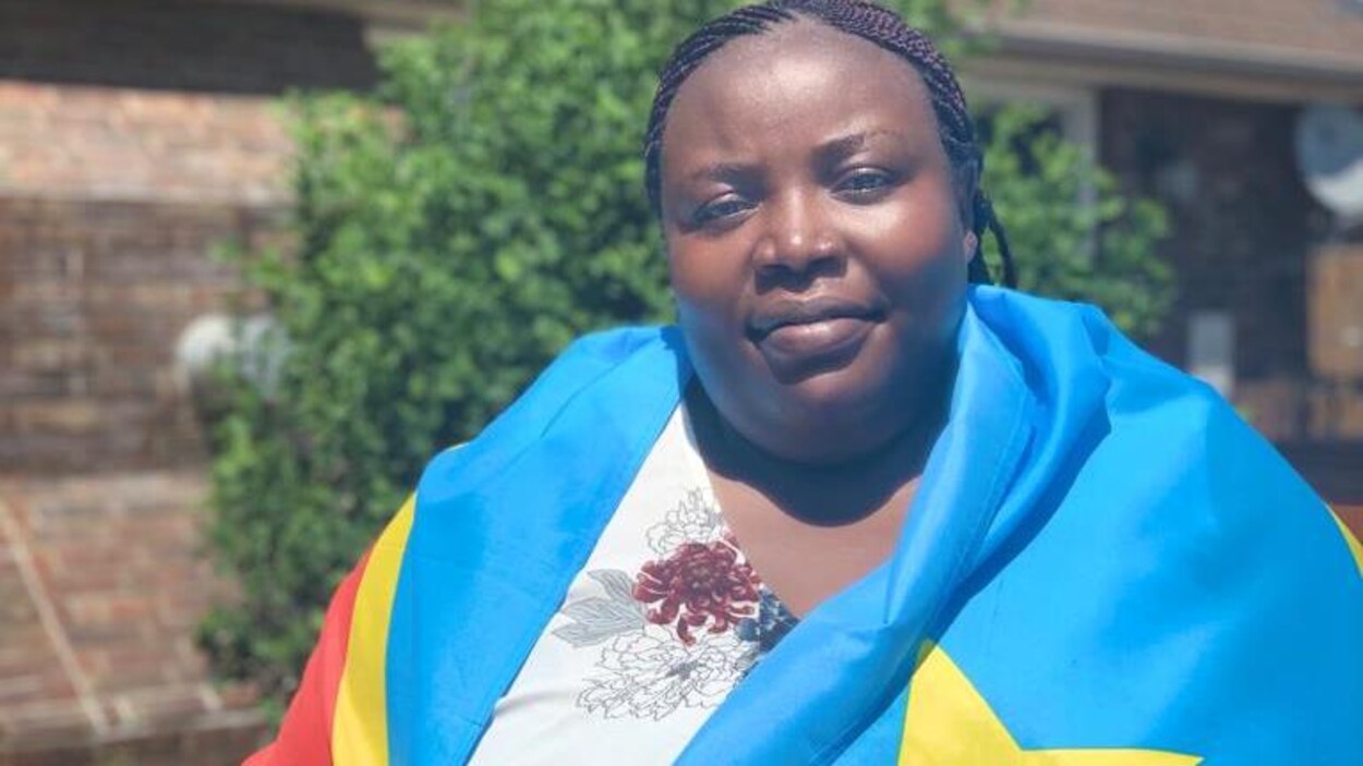 Une femme pose avec un drapeau sur les épaules