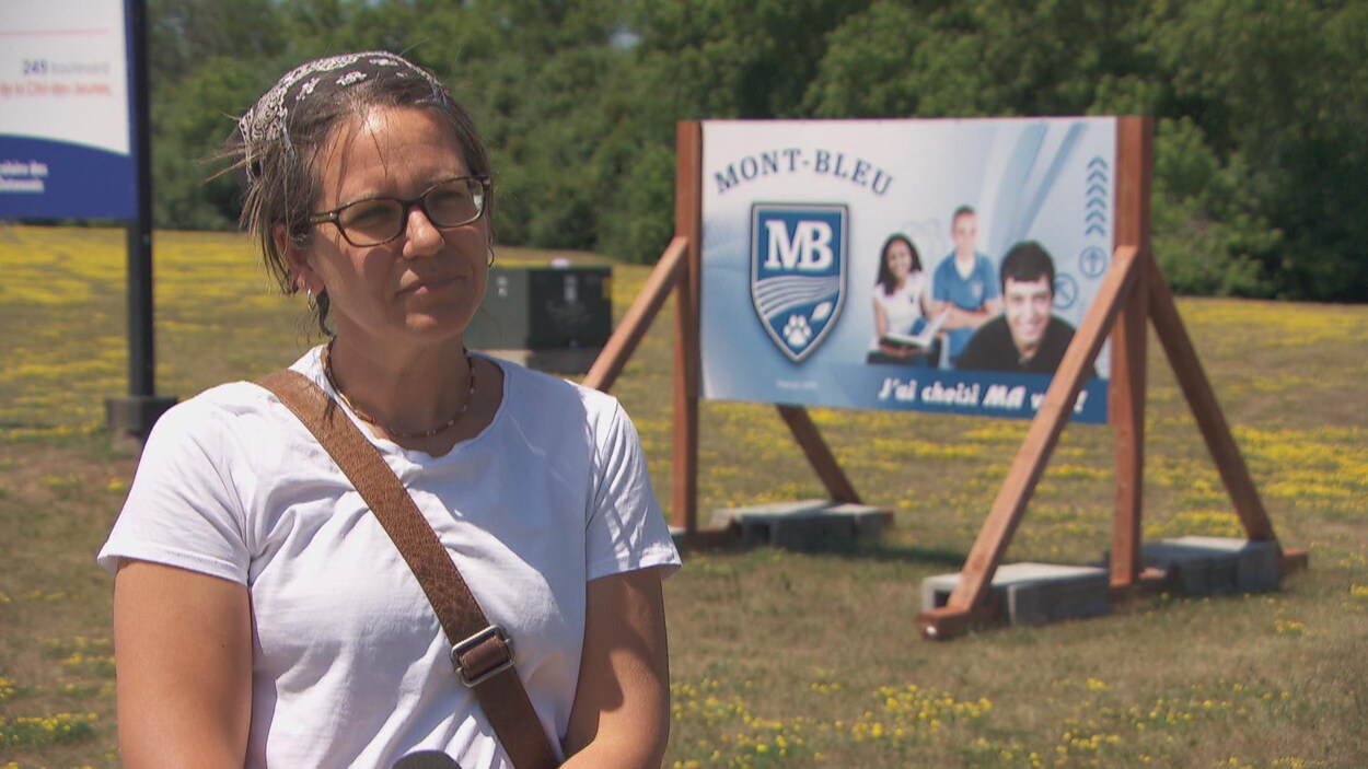 Marie Hélène Bélisle répond aux questions devant un panneau de l'école Mont-Bleu.